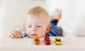 Chłopiec bawi się samochodzikami, tworząc własny świat. Czasem samotność jedynaka wypełnia wyobraźnia.
