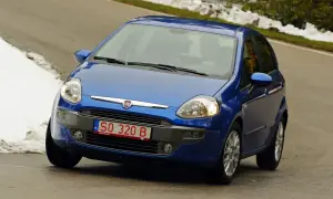 Niebieski Fiat Punto na drodze, z widoczną czerwoną rejestracją SO 320 B.
