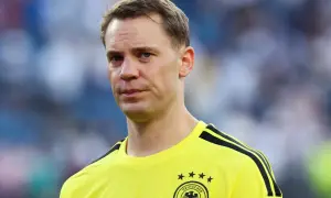 Manuel Neuer, bramkarz w żółtej koszulce z czarnymi pasami, gotowy do gry.