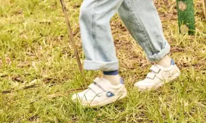 Białe sneakersy na rzepy, idealne na spacer po trawie. To wygodne buty dla aktywnych.