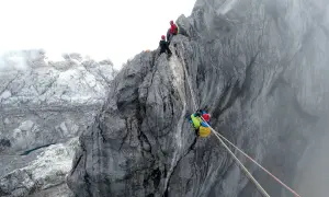 Wspinaczka na piramidę Carstensza. Alpinisci zmagają się z trudnym terenem skalnym, używając lin do asekuracji.