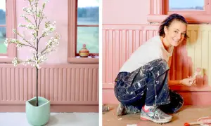 En kvinna målar ett element rosa. En konstgjord blommande körsbärsgren står i en ljusgrön kruka.
