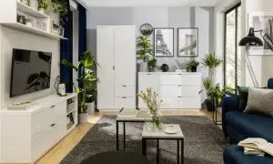 Nowoczesny salon z białymi meblami, granatową kanapą i mnóstwem zieleni. Inspiracja, jak ustawić kwiaty w salonie, by stworzyć przytulną atmosferę.