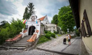 Droga do Sanktuarium Matki Bożej w Trzcińcu Lubelskim. Mężczyzna z wózkiem idzie brukowaną uliczką.