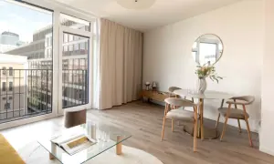 Nowoczesne mieszkanie inwestycyjne co to znaczy? Jasny salon z jadalnią, balkonem i widokiem na miasto.