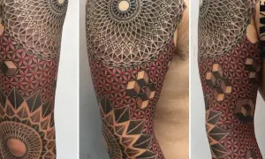 Brazo con tatuajes tradi geométricos, mandalas y flor de la vida en rojo y negro.