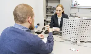Mężczyzna przekazuje dokument do wymiany prawa jazdy urzędniczce.