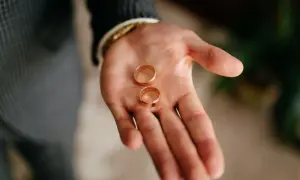 Dwie złote obrączki na dłoni. Co oznacza zgubiona obrączka? Symbol utraty, ale też szansa na odnalezienie.
