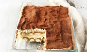 Pyszne tiramisu w szklanej formie, posypane kakao. Idealne, gdy wiesz, jak sparzyć jajka do tiramisu.