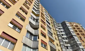 Wysoki, żółty blok mieszkalny z balkonami. Szukasz informacji, jak wypełnić wniosek o mieszkanie komunalne wzór?