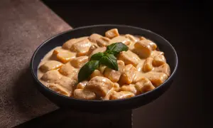 Cremige Gnocchi Gorgonzola in einer Schüssel, garniert mit frischem Basilikum. Ein Genuss für Feinschmecker.