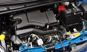 Silnik Toyoty Yaris 2017: czarny plastikowy osłona, akumulator Varta, niebieska belka.
