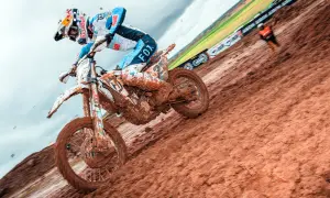 Motocyklista w błocie podczas wyścigu motocrossowego.