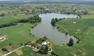 Widok z lotu ptaka na jezioro, pola uprawne i zabudowania w Przechlewie.