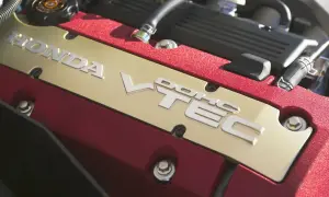 Złota pokrywa silnika Honda z napisem VTEC. Czerwone, teksturowane wykończenie dodaje sportowego charakteru.