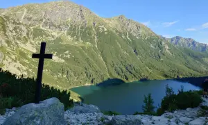 Czarny krzyż na skale, z widokiem na jezioro i góry. To nie najwyższy szczyt w Polsce, ale widok zapiera dech.