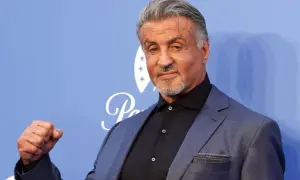 Sylvester Stallone, gwiazda wielu kultowych filmów, pozuje z zaciśniętą pięścią.