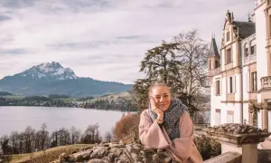 Frau genießt Aussicht auf See & Berge bei Luzern. Entdecke Luzern Geheimtipps von diesem malerischen Ort aus.