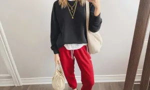Styling-Idee: Schwarzer Pullover, weiße Schicht, rote Hose mit weißen Streifen, Leo-Sneaker und cremefarbene Taschen. Perfekt, wenn du fragst, was passt zu roter Hose!
