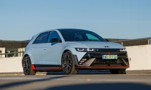 Sportowy Hyundai Ioniq 5 N w kolorze jasnoszarym z czerwonymi akcentami, zaparkowany na zewnątrz.