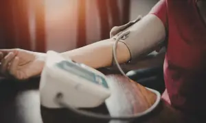 Osoba mierzy ciśnienie krwi. Może to być związane z przyjmowaniem leku, np. chlortalidonu, który pomaga regulować ciśnienie.