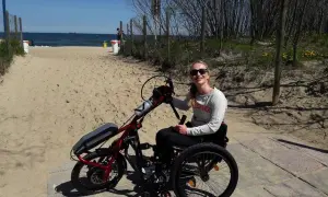 Kobieta na wózku inwalidzkim z napędem elektrycznym na plaży.