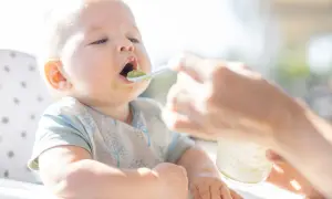 Niemowlę karmione mlekiem modyfikowanym otwiera buzię na łyżeczkę z zielonym puree. Czas zacząć rozszerzać dietę!