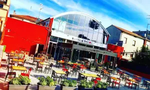 Birrificio Renton, una moderna hilltop brewery con tavoli all'aperto sotto un cielo azzurro.