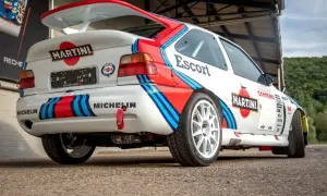Biały Ford Escort Cosworth w barwach Martini Racing, z dużym tylnym spojlerem i licznymi naklejkami sponsorów.