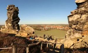 Felsformationen bei Blankenburg, ein echter Geheimtipp mit Blick auf ein malerisches Dorf. Wanderer genießen die Aussicht.