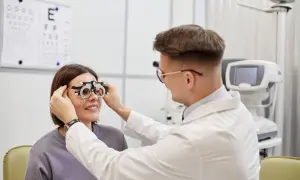 Okulista bada wzrok pacjentki. Zastanawiasz się, ile zarabia technik okulista?