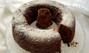Un delizioso ciambellone al cioccolato, cosparso di zucchero a velo, pronto per essere gustato.