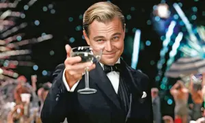 Jay Gatsby wznosi toast kieliszkiem szampana, otoczony blaskiem imprezy. Jego spojrzenie pełne jest obietnicy i tajemnicy, jak w filmie "Wielki Gatsby".