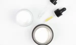 Dwa słoiczki z kremem i pipetki z serum, w tym jedno z kwasem glikolowym, gotowe do pielęgnacji.