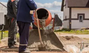 Robotnicy mieszają beton. Zastanawiasz się, ile piasku i cementu na m3 wylewki?