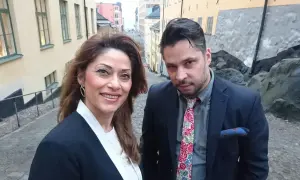 Azita Shariati och en man på en kullerstensgata i Stockholm.