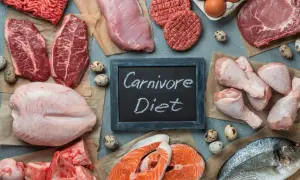Różnorodne mięsa, ryby i jaja na stole. Tabliczka z napisem "Carnivore Diet" sugeruje potencjalne dieta karniwora efekty.