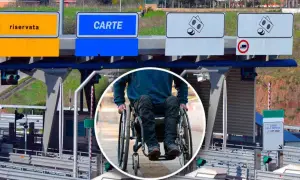 Persona in carrozzina alla stazione di pedaggio autostradale, con segnali per corsie riservate e carte, per l'esenzione pedaggio autostradale invalidi.