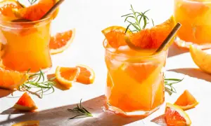 Erfrischender Aperitif mit Prosecco, Orangenstücken und Rosmarin. Perfekt für einen sonnigen Nachmittag.