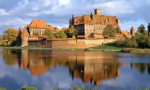 Malbork, największy zamek w Polsce, majestatycznie odbija się w tafli wody.