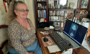 Une femme consulte des archives en Sarthe sur son ordinateur, où s'affiche le portrait d'une religieuse.