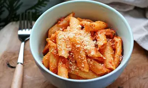 Penne z sosem pomidorowym, posypane parmezanem. Idealne danie z pomidorkami datterini.