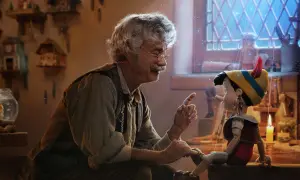 Gepetto pratar med Pinocchio, en docka som ser ut att vara från klassiska familjefilmer. En magisk stämning med gnistrande ljus.