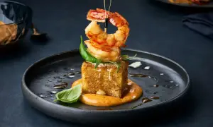 Gegrillte Garnelen auf einem knusprigen Würfel, garniert mit Basilikum. Eine köstliche Präsentation von Garnelenarten zum Essen.
