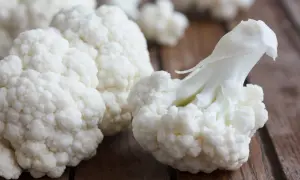 Świeże różyczki kalafiora na drewnianym blacie. Czy kalafior jest zdrowy? Tak, to warzywo pełne witamin i błonnika!