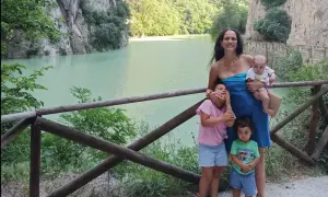 Famiglia felice nella Gola del Furlo, con un lago turchese e rocce imponenti.