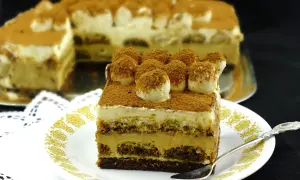 Pyszny sernik tiramisu, warstwowy deser z kremem i biszkoptami, posypany kakao.