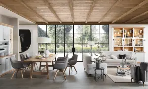 Stilvolle Esszimmer Wand Ideen: Holzbalkendecke, große Fensterfront mit Gartenblick, Esstisch mit grauen Stühlen, gemütliche Sofalandschaft und Bücherregal.