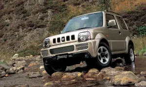 Złoty Suzuki Jimny (1998) pokonuje kamienisty strumień, gotowy na każdą przygodę.
