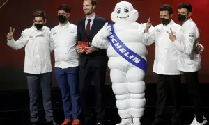 Chefs celebran con el muñeco Michelin, un símbolo de excelencia culinaria y 5 estrellas Michelin.